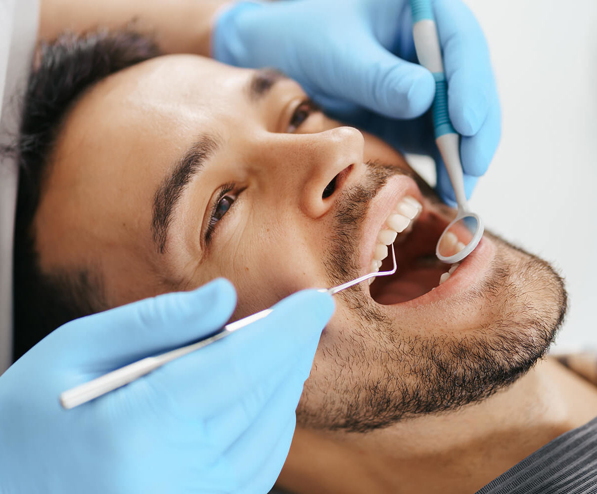 Hombre sonríe durante revisión dentista